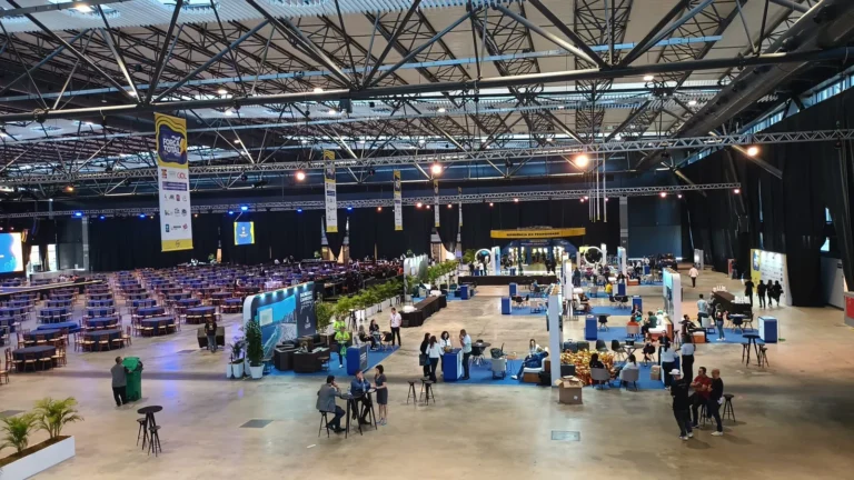 Pavilhão de feira com estandes e visitantes