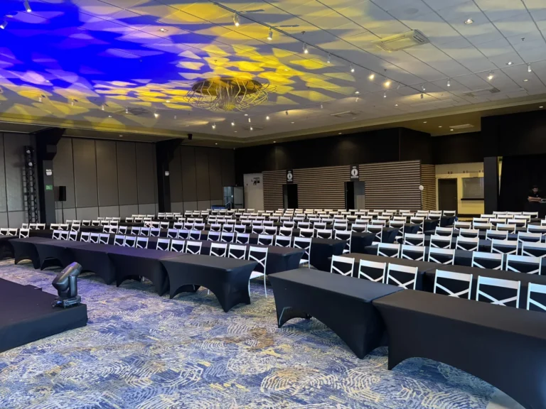 Salão de evento com forro iluminado e mesas