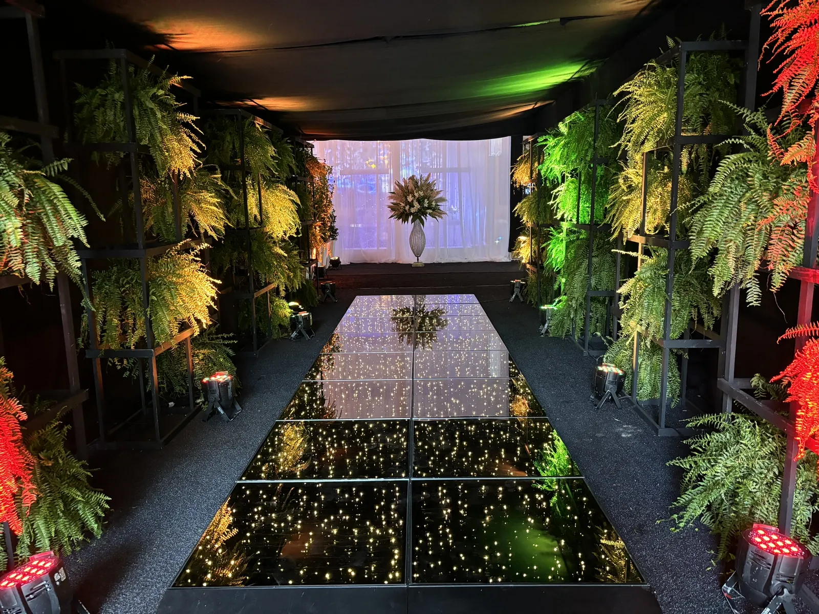 Corredor iluminado com arcos verdes na formatura