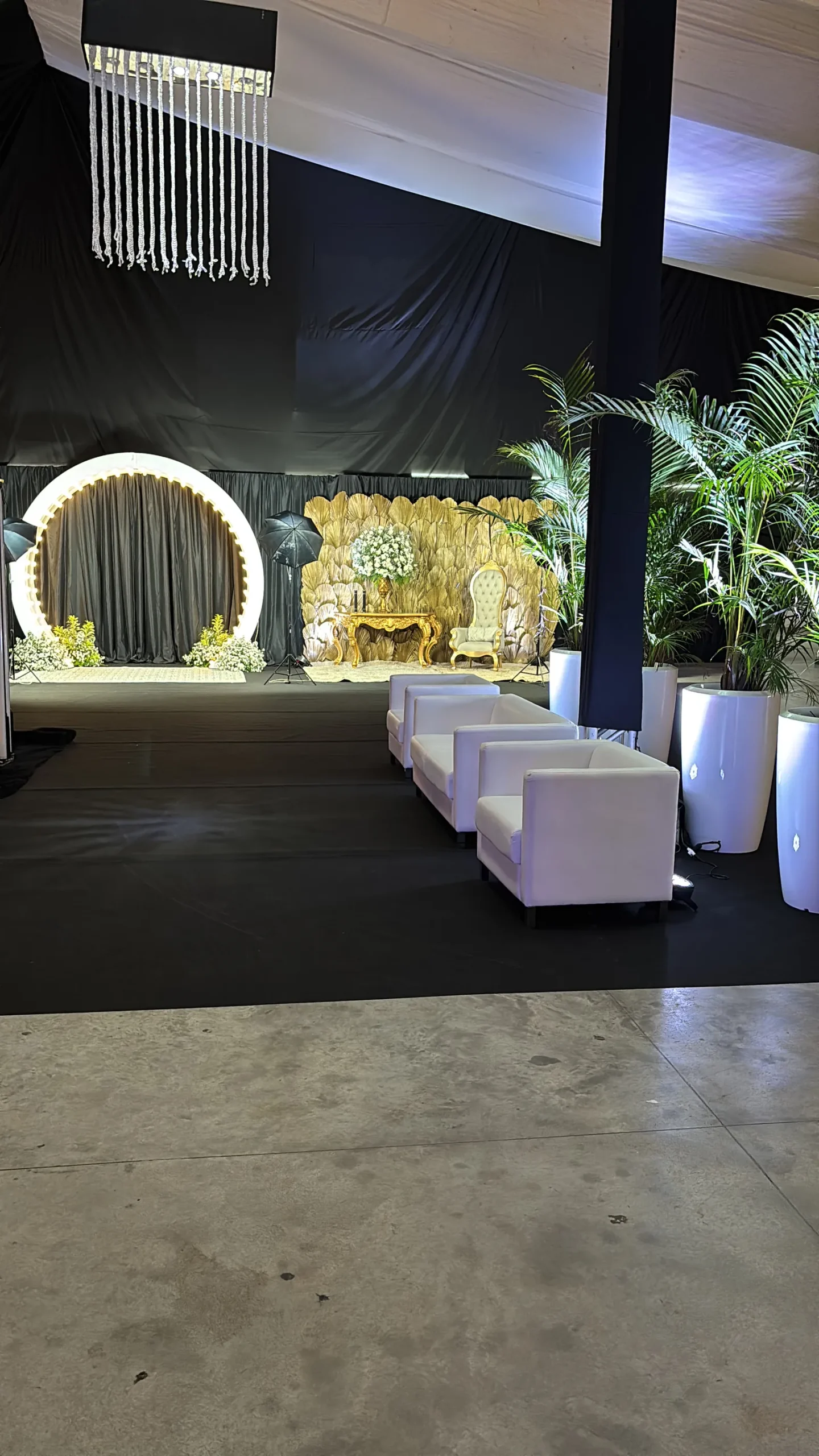 Entrada decorada com arco, poltronas e plantas